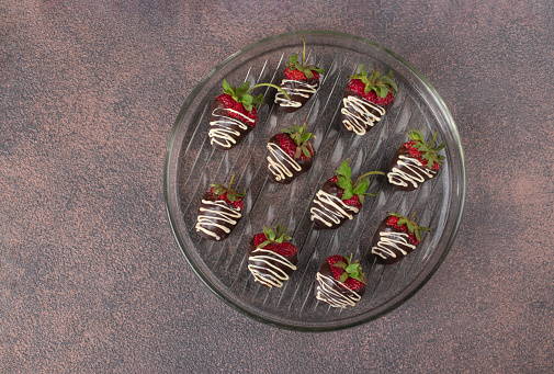 Delicious chocolate covered strawberries on brown background, Top view