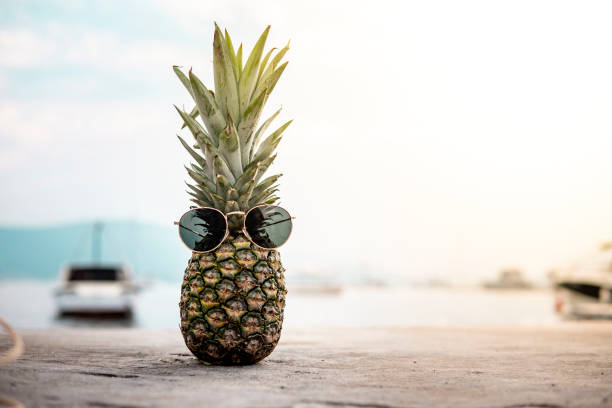 Pineapple with sunglasses by the sea