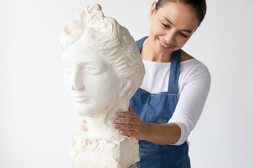 Female Sculptor is working at her studio.