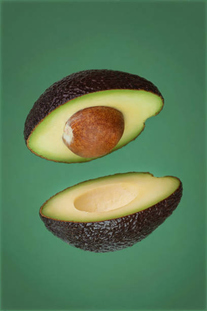 istock flying cut avocado on green background 1414660870