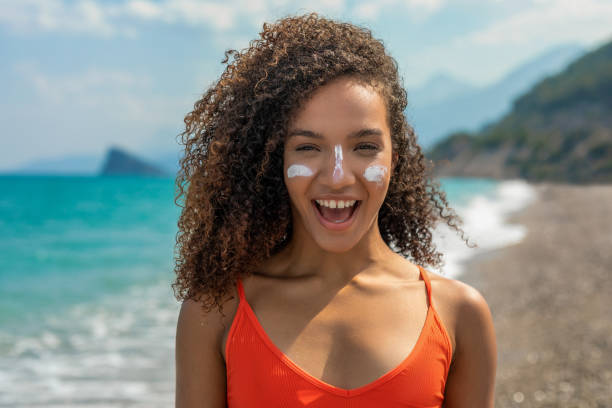 istock Woman having a sunscreen applied to her face 1414661724