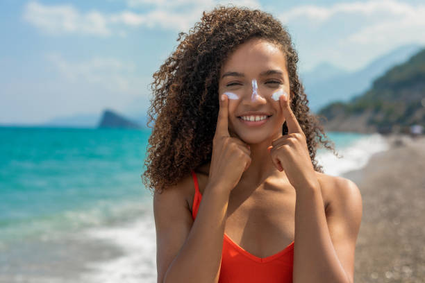 Woman having a sunscreen applied to her face Woman having a sunscreen applied to her face SPF stock pictures, royalty-free photos & images