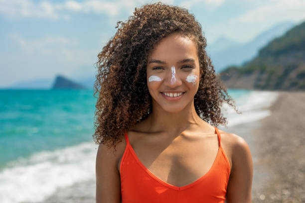istock Woman having a sunscreen applied to her face 1414661778