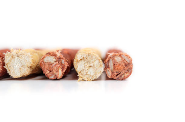 Front with of multiple chicken and beef flavored chew sticks. Dental health treats for dogs and behavioral enrichment. Selective focus. White Background.