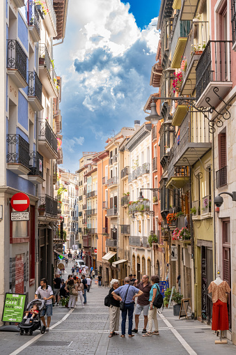 Pamplona, Spain - June 2, 2022: A group of tourists gather on a colorful street in Pamplona, Spain.