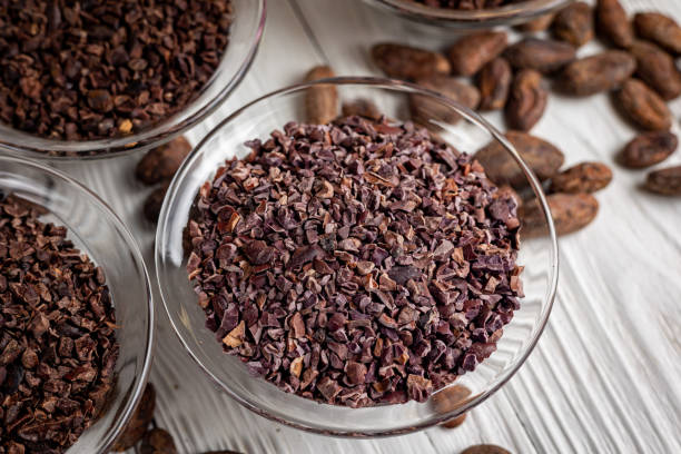 nibs de cacao con granos de cacao sobre fondo de madera vieja - plumín fotografías e imágenes de stock