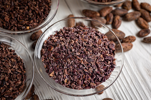 Cacao nibs with cacao beans on old wooden background