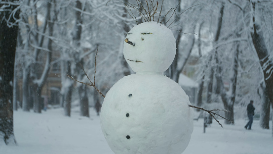 Happy funny snowman, on background of a strong snowfall.