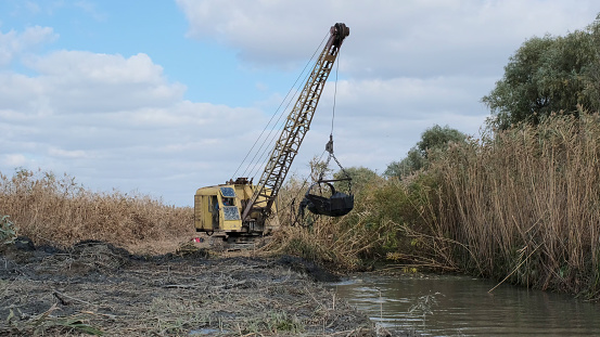 Excavator deepens and widens the canal between the Danube River and the lakes