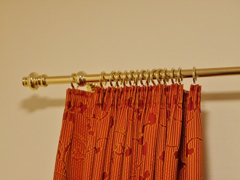 Brass curtain rod with orange curtain