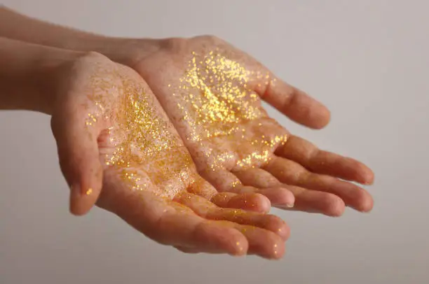 Gold Glitter on hands. Blessings gratitude