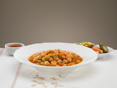 Chickpeas in tomato sauce in bowl closeup.