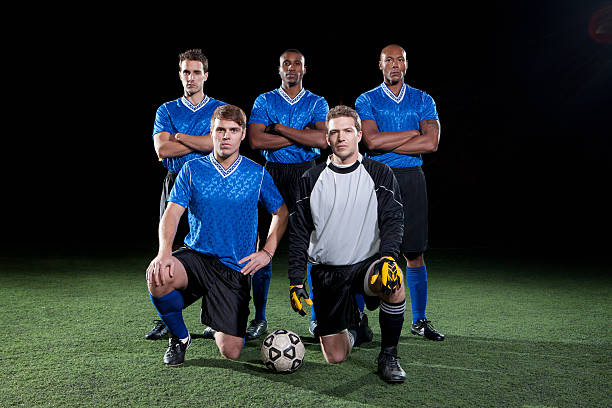 equipa de futebol no campo à noite - clothing team sport serious viewpoint imagens e fotografias de stock