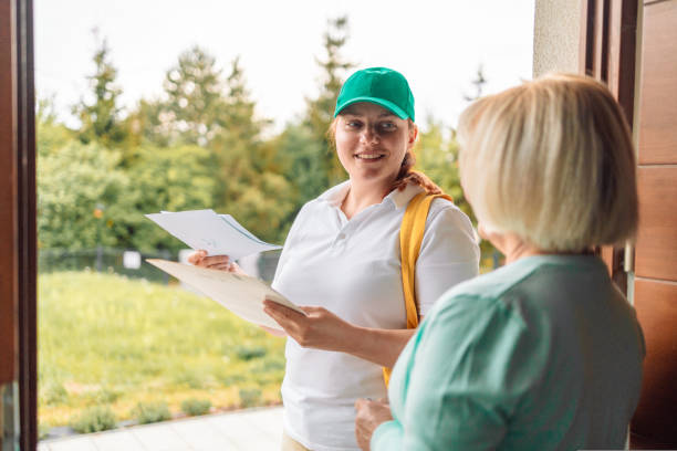 istock `Unrecognisable woman making a deliver postman mail envelope to a customer at their home. 1414678165