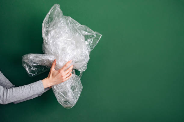 Woman working in a recycling center sorting some bottles and looking very happy - environmental concepts