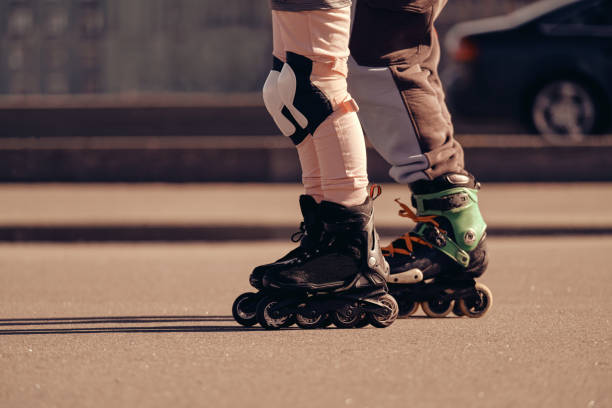 istock Two roller skaters ride on roller skates next to the road 1414684550