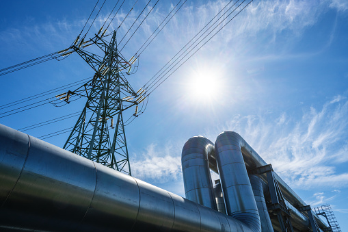 Industrial pipelines on pipe-bridge against blue sky