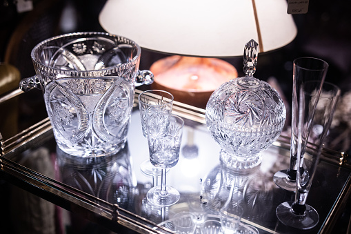 This image shows a defocused macro texture view of a shimmering antique lead crystal glass bowl with light reflecting diamond cuts and a scalloped edge.