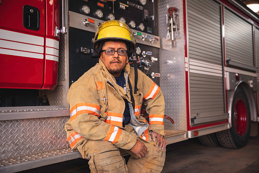 A middle-aged Navajo man and firefighter poses for portraits in the fire station on the Navajo Reservation where he works. Image taken in Utah, USA.