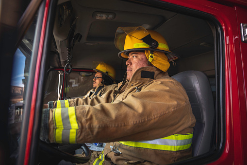 Two male firefighters sitting in a fire truck are ready to head out to fight fires on the Navajo Reservation, Utah.