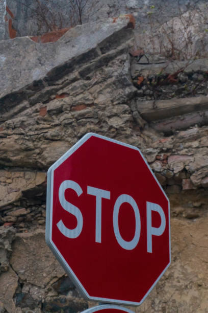 istock Red stop sign on the background of a destroyed brick wall 1414689781