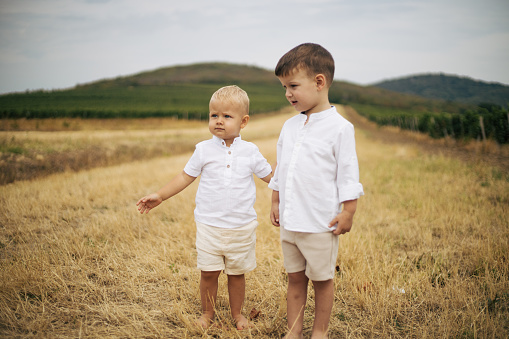 White T-shirt andmdresses, all in amazing and beautiful family atmosphere. Children with big smiles and positive energy making vineyard look as heaven on Earth. Mother is always there to make everything even better. With flowers on girls head.