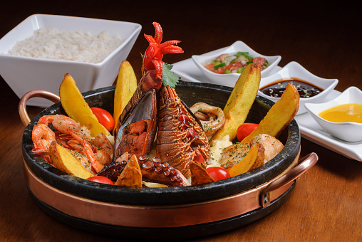 Dish with seafood, with octopus, mussels, shrimp, lobster and squid, accompanied by potatoes, rice and sauces.