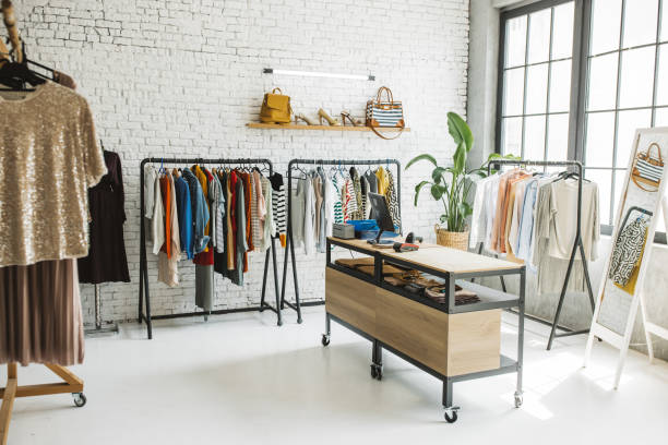 Sustainable shopping Shot of an empty clothing boutique with computer on a desk. clothes shop stock pictures, royalty-free photos & images