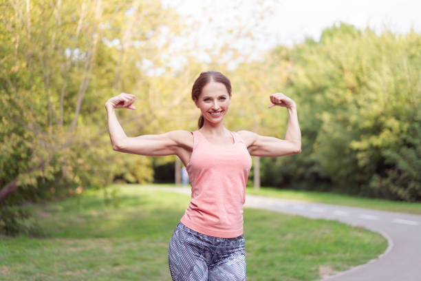 istock Woman runner stretching arms before running summer park 1414698589