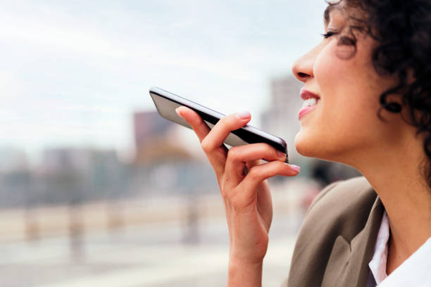 istock woman smiling recording a message with a mobile 1414698903