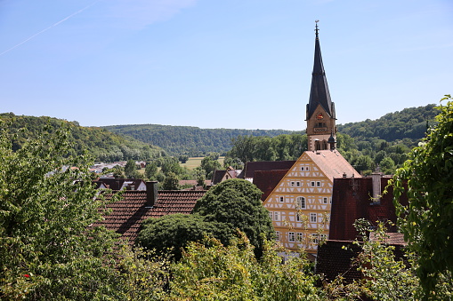 Scenic view of old German village with church, big old fachwerk house and greenery