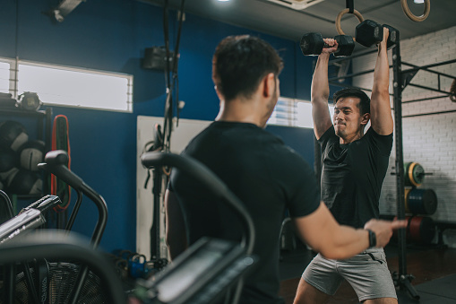 Asian Chinese Gay Couple routine workout in gym