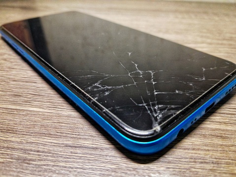 cracked cellphone screen on wooden table
