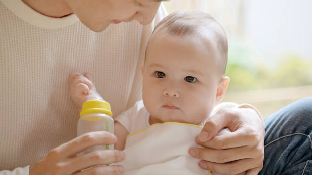istock father feeding milk to baby 1414704604