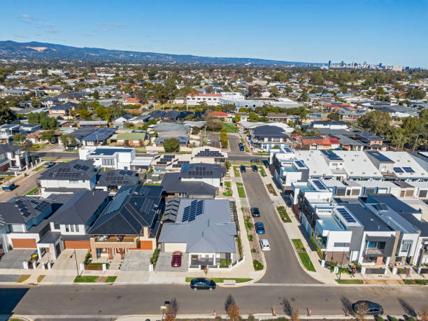 Aerial view looking down on new, modern housing development with mixed house & architectural styles, city in distance
