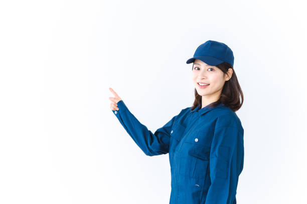 istock Young woman in work clothes smiling and pointing 1414712042