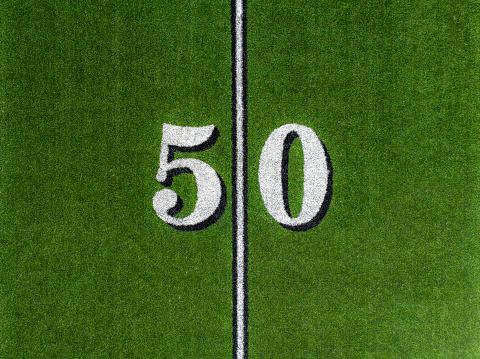 Aerial image of a typical synthetic turf football field 50 yard line in white.