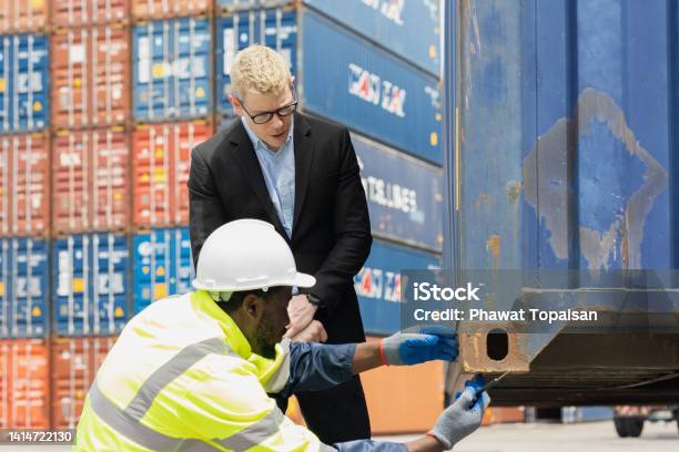 Container import export and logistic concept. Foreman and engineer meeting to checking inventory or job details with cargo container background.