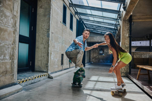 istock Couple playing skateboard together outdoor. 1414726144