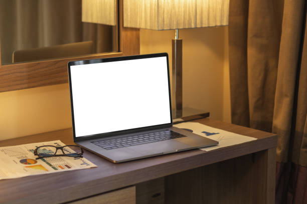 istock Laptop with blank screen on table in hotel room or home, mockup. Empty screen for advertise concept 1414728238