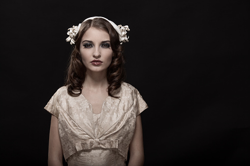 Young queen. Portrait of adorable girl in image of medieval royal person in renaissance style dress isolated on dark background. Comparison of eras, beauty, history, art, creativity.