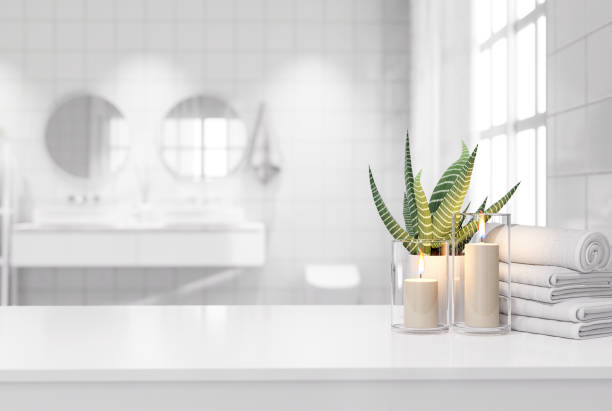 Blank white table top for copy space 3d render Blank white table top for copy space 3d render decorated with glass candle holders with flames. cotton towel and a potted plant with a blurry bathroom background. bathroom stock pictures, royalty-free photos & images