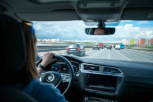 istock Woman driving a car at multiple lane highway 1414733809