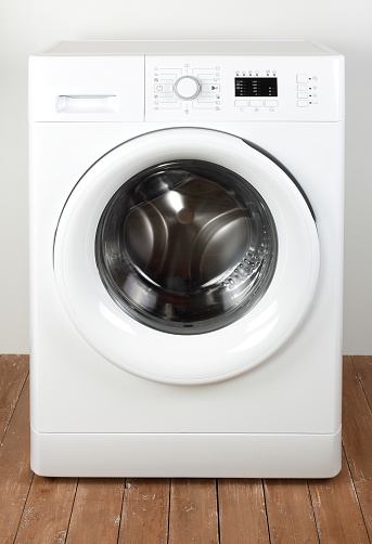 Major appliance - Front view close door washing machine on a white and wood background