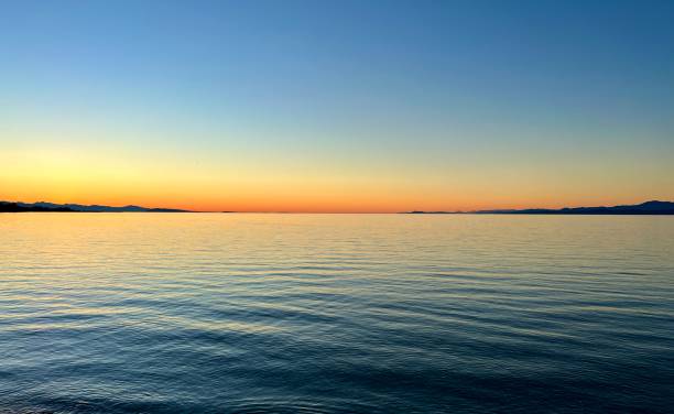 海辺の美しい夕日、鮮やかなオレンジ色の赤い海岸線のスカイライン - horizon over water malibu california usa ストックフォトと画像