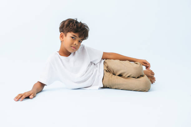 istock Lying on the floor on his side Indian boy against bluish white background 1414737914
