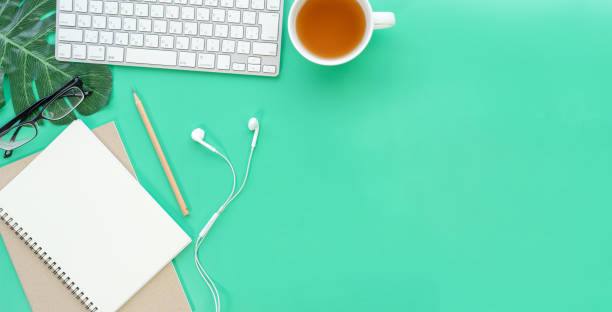 istock Flat lay of top view desk work table with Coffee computer notebook and pencil work space in minimal green color spring tone concept includes copyspace for add text or graphic 1414739247