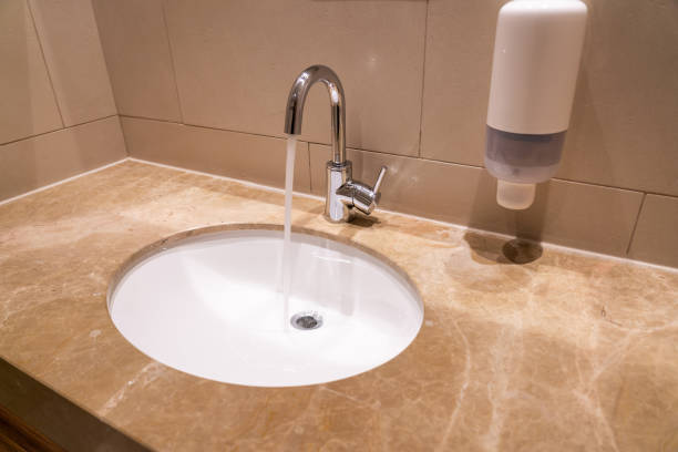 istock Sink with faucet in a hotel bathroom on a granite base 1414741632