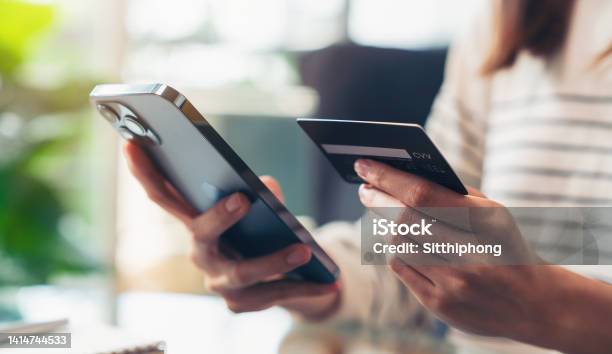 Woman Hand Holding Credit Cards And Using Smartphone For Shopping Online With Payment On Internet Banking Stock Photo - Download Image Now