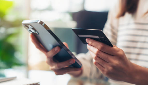 fotografii de stoc, fotografii și imagini scutite de redevențe cu femeie care deține carduri de credit și folosește smartphone-ul pentru cumpărături online cu plată pe internet banking. - plată